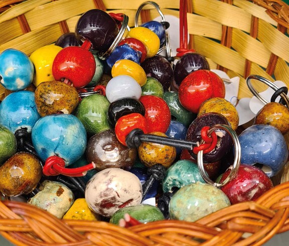 Schlüsselanhänger aus bunt glasierten Tonkügelchen in Körbchen